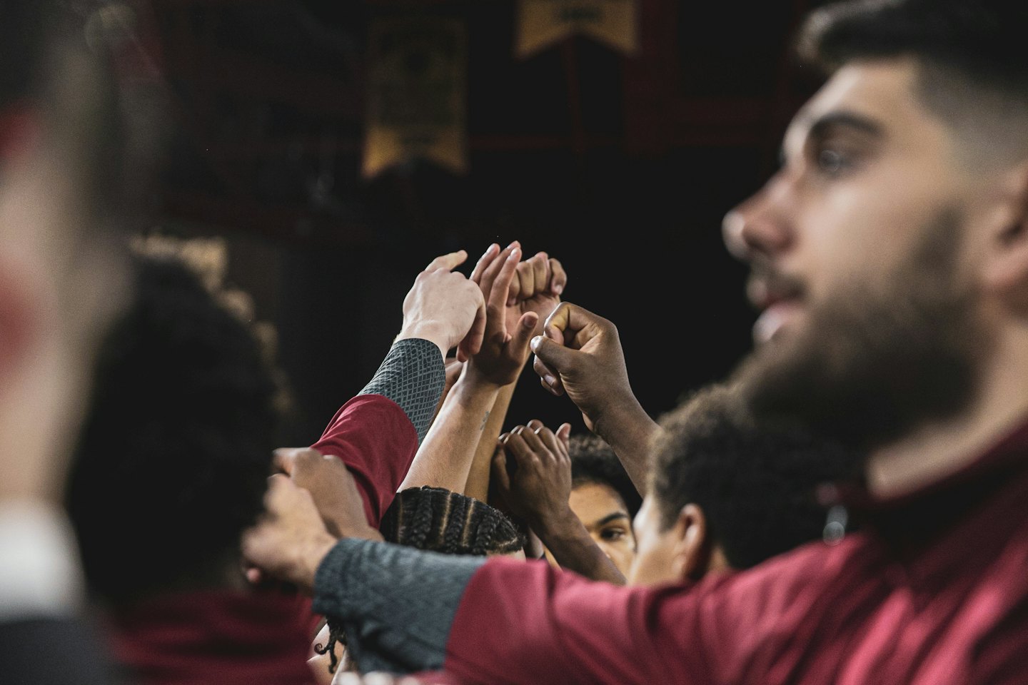 Athletes stack their hands together in a gesture of unity.